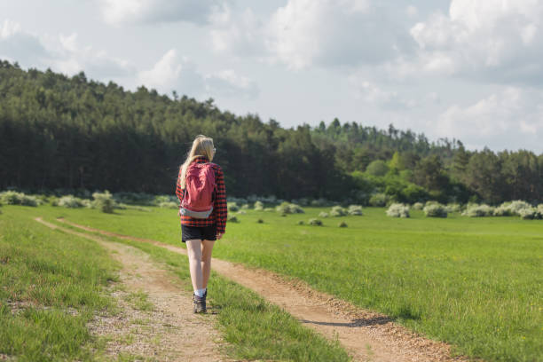 Young woman hiker walking and looking at beautiful nature view
