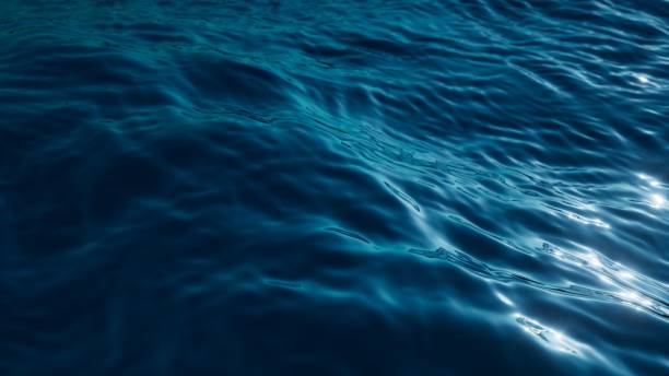 istock 3d render, abstract background of a tranquil and deep blue water surface, with gentle ripples catching the light, conveying a sense of calm and depth. Wallpaper of wavy sea surface 2150571251
