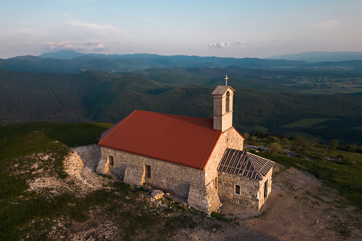 Beautiful old church on the mountain top with scenic surroundings landscape, aerial shot. Traveling concept.