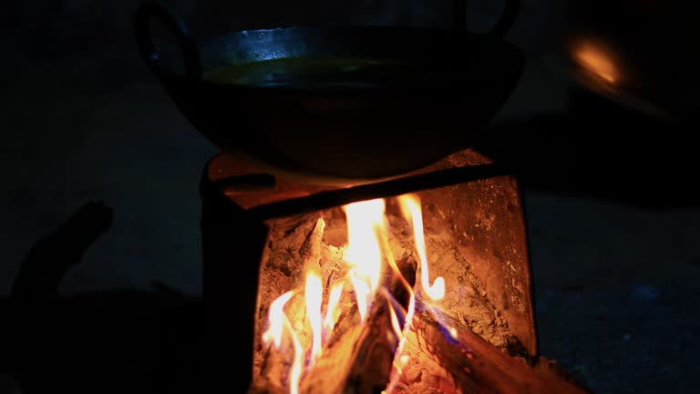 Traditional Outdoor Cooking Over Open Wood Fire at Night