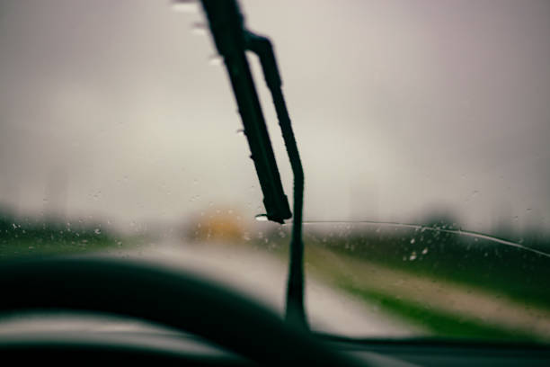 istock Windshield wipers cleaning raindrops from a windshield glass car 2150574095