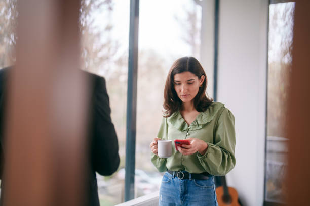 istock Business people using mobile phone in office at coffee break. 2150577682