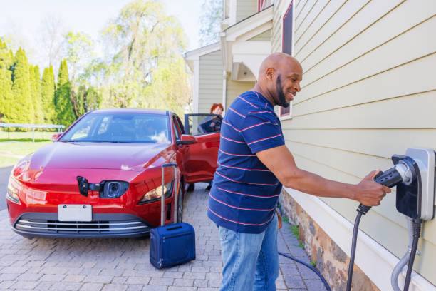 istock Family home charging solutions for EV. Smiling mature man plugging a charging cable into a charger installed at his suburban home in Madison, NJ 2150578392