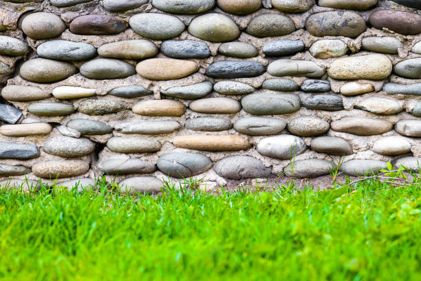 fragment of a wall made of rounded stones. fence made of stones. masonry background. stone texture.