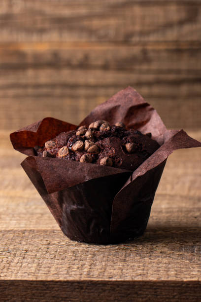 istock Chocolate dark muffin with chocolate chips and drops on a wooden table 2150579670