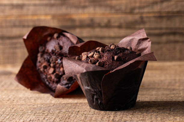 istock Chocolate dark muffin with chocolate chips and drops on a wooden table 2150579673