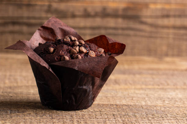 istock Chocolate dark muffin with chocolate chips and drops on a wooden table 2150579734