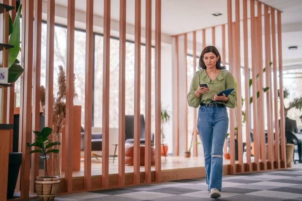 istock Businesswoman using mobile phone and digital tablet in office hall. 2150579852