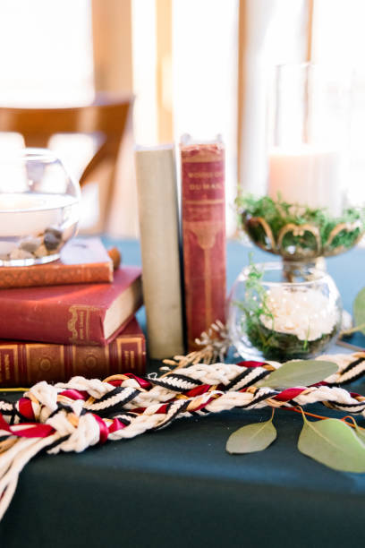 A unity rope is on a table with stacked old books in a romantic table setting at a book-themed wedding