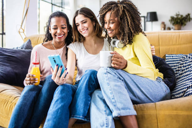 istock Young multiracial friends using a mobile phone together at home. 2150586114