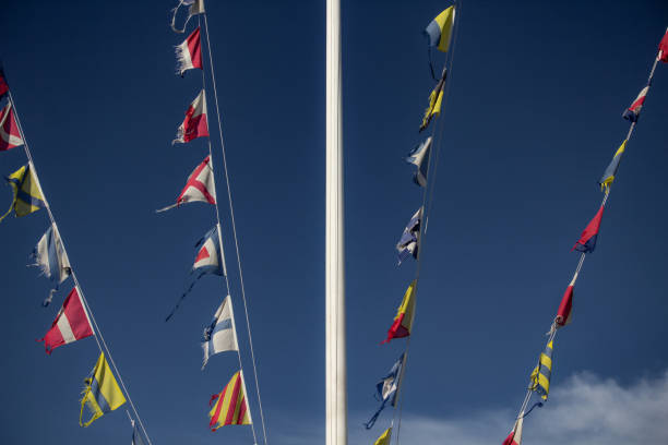 The flags are evenly spaced, representing national colors that are often seen together on a single flag but here are separated. This visual separation of colors traditionally associated with a single national identity evokes themes of division, fragmentation, and the idea of secession. The muted colors and overcast sky add a somber tone, hinting at concepts of disunity, ideological splits, or shifts in unity. Each flag flutters individually, suggesting a break from a unified identity and the complex dynamics of nationalism and cultural symbolism. CGI