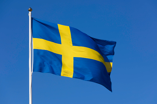 A swedish flag in the wind on a sunny day.