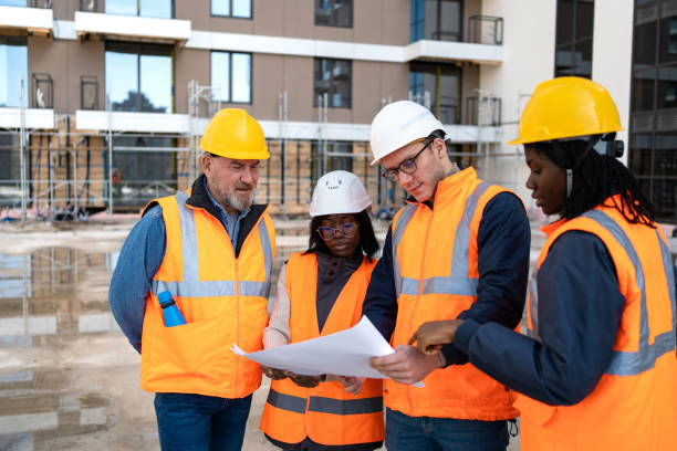 istock Team of construction worker going through blueprint at construction site 2150598836