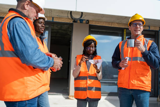 istock Multiracial construction team having fun during lunch break on building rooftop at construction site 2150599089