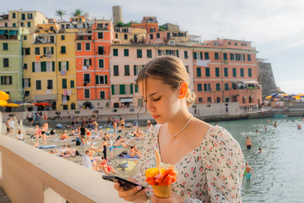 istock Girl using smartphone while eating  gelato in Cinque Terre 2150599583