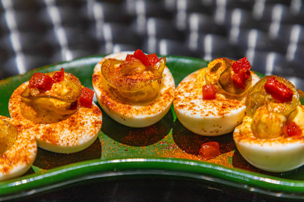 Fall pumpkin theme deviled eggs. Overhead view table scene on a dark background. Autumn breakfast concept.