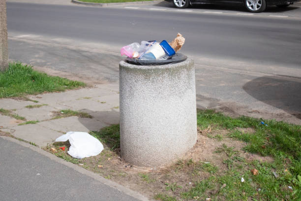 istock Public trash can on a city street filled with garbage 2150604097
