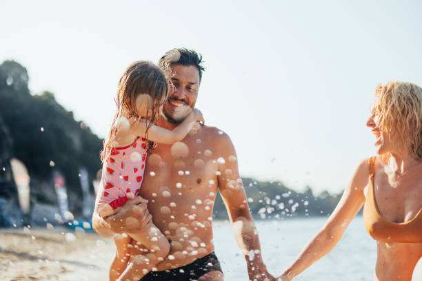 istock Happy Family of Three at the Beach 2150604607