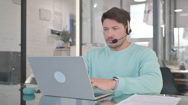 istock Man in Call Center with Headset Working on Laptop 2150605822