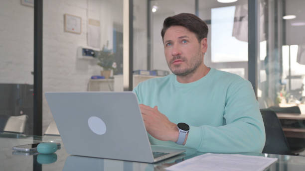 istock Pensive Casual Man Working on Laptop 2150605991