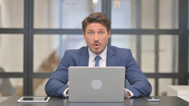 istock Surprised Middle Aged Businessman Wondering in Awe at Work 2150610455