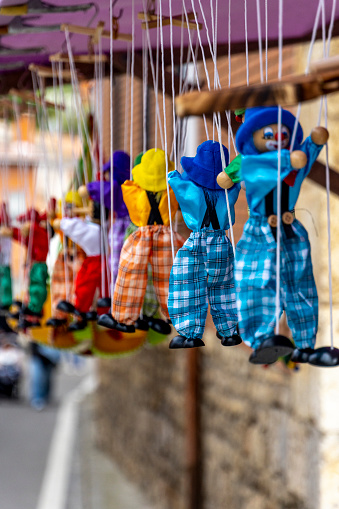 String puppet for sale at a medieval market, toy clowns dangle from strings at an open-air stall - Valladolid