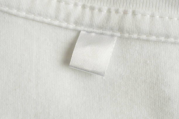 istock Blank white laundry care clothes label on white shirt fabric texture background 2150611755