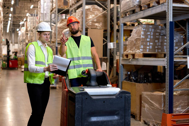 istock warehouse workers men in reflective jackets pulling a pallet truck and talking 2150616000