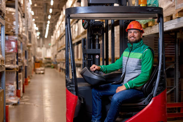 istock man in protective safety jumpsuit uniform in hardhat at warehouse working with forklift 2150616015
