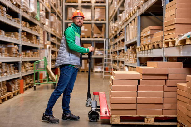 istock nice warehouse worker with manual pallet jack, working in storage room, transporting goods 2150616038