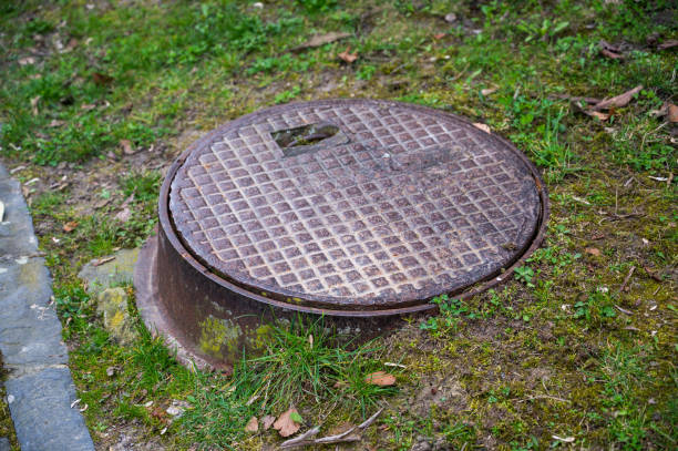 istock Brown metal sewer cover in the grass. 2150617496
