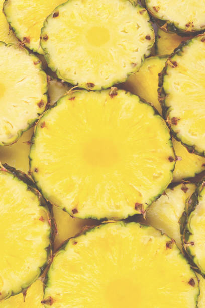 Pineapple juicy yellow slices background. Top view.