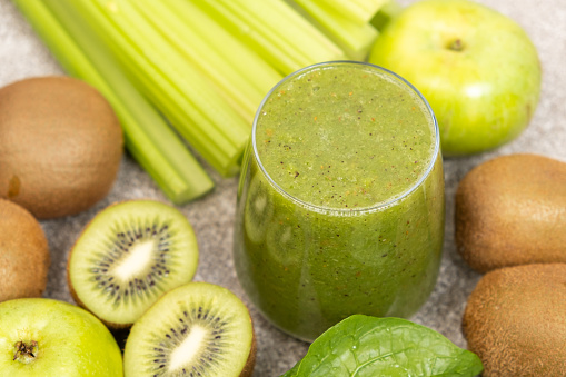 Green smoothie with kiwi, apples, celery, spinach, a healthy natural foods dish.