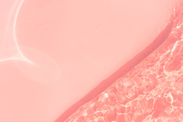 istock Pink water bubbles on the surface ripples. Defocus blurred transparent pink colored clear calm water surface texture with splash and bubbles. Water waves with shining pattern texture background 2150621333