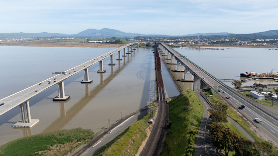 Aerial stock photo of the Benicia-Martinez Bridge and the George Miller Jr. Memorial Bridge connecting Benicia and Martinez in Northern California.