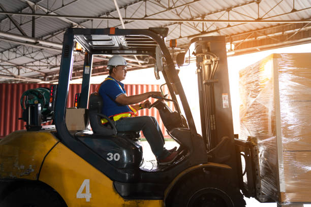 istock Warehouse worker driver in uniform delivery and loading pallet product. 2150628348