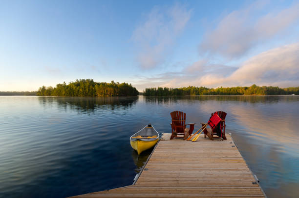 istock Adirondack chairs on a dock overlook the lake 2150628384