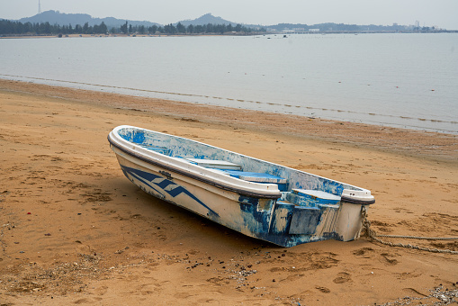 Close-up of abandoned wooden boat on the beach by the sea
