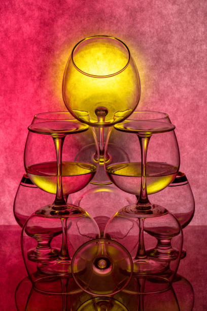 Still life with glassware with liquid on colored background