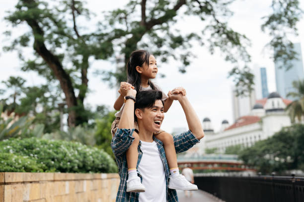 istock Father carrying daughter on shoulder and looking at view 2150631071