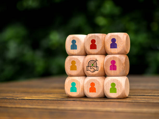istock Stakeholder, business connection, teamwork, partnership and team building concept. Target with handshake deal icon surrounded with multicolor businessman symbol on white cube blocks stacked as one. 2150631852