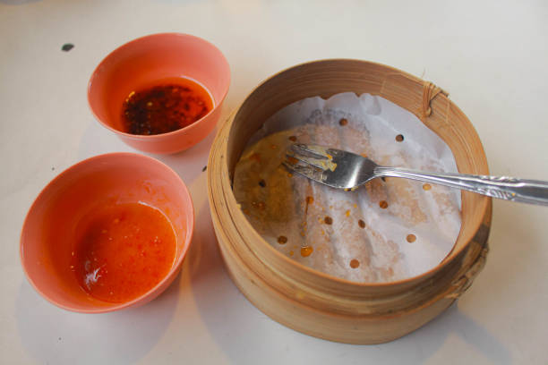 After eat dim sum in restaurant table. Bamboo streamer and sauce in bowl.