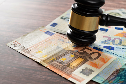 Gavel and stack European Union currency on the table.