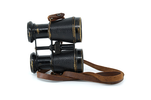 Antique pair of black binoculars with brown leather straps isolated on white background