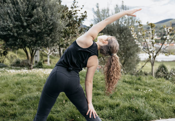 istock Woman doing reverse warrior yoga pose in nature, copy space. 2150643950