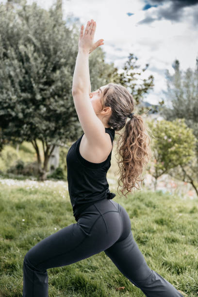 istock Woman Practicing High Lunge Yoga Pose in Park 2150643953