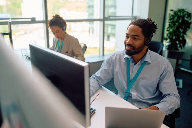 istock Happy black entrepreneur multitasking while working on desktop PC and laptop in the office. 2150644335