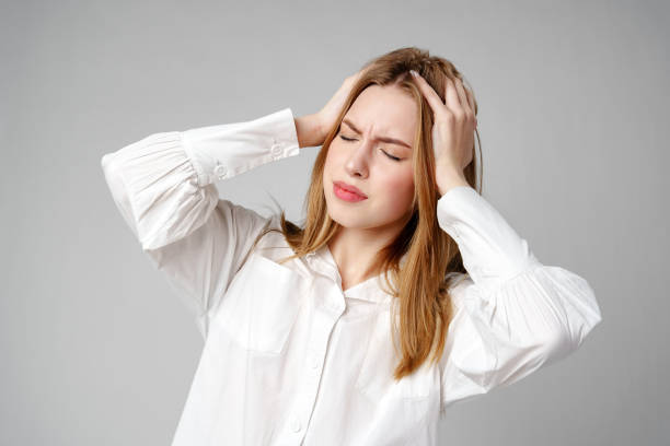 istock Woman With Hands on Head Suffering Headache 2150644361