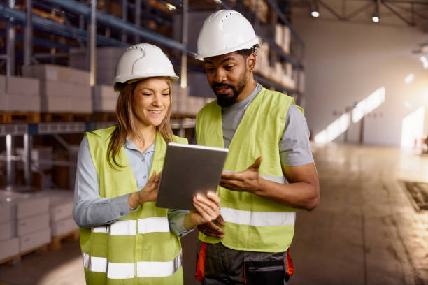 istock Black worker and female inspector working on touchpad in storage room. 2150644439
