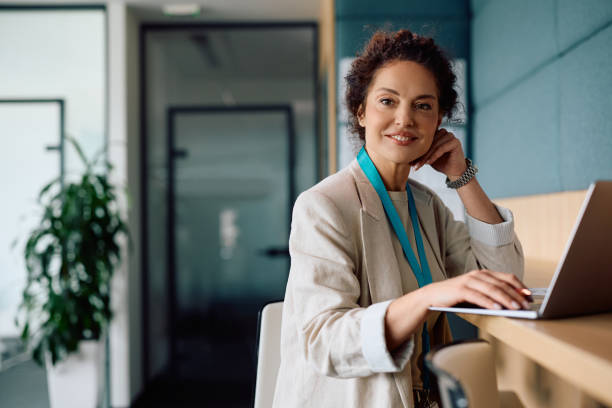 istock Happy businesswoman using laptop while working in the office and looking at camera. 2150644600